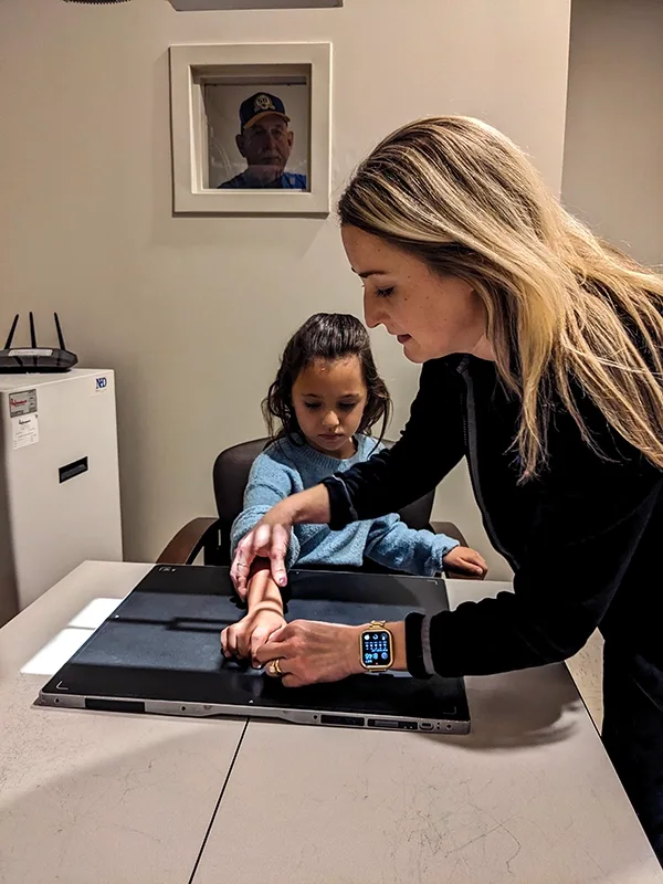 Young girl getting her arm positioned for an x-ray