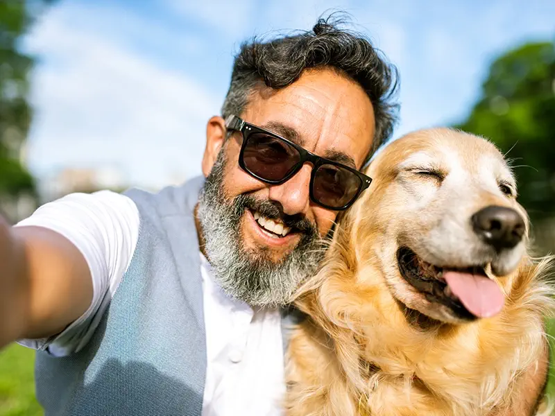 Man enjoying time with dog at a field after hormone therapy