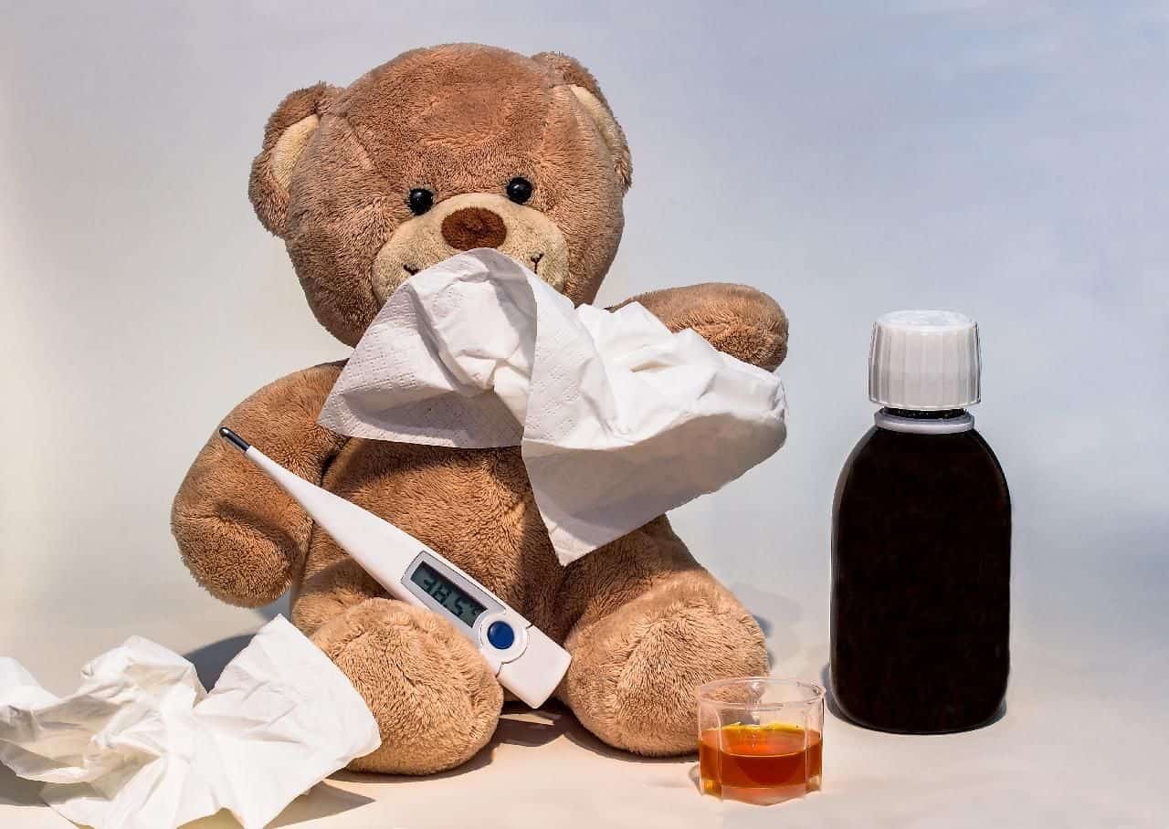 A teddy bear propped up to look like they have the flu.
