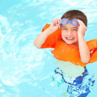A young boy floating in a pool.