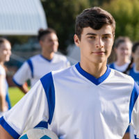 An older teen looking forward in a soccer uniform.