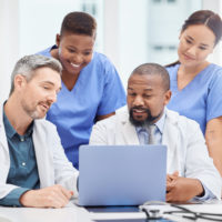 Several doctors looking at a computer.